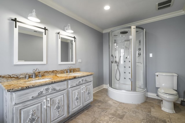 bathroom with vanity, toilet, a shower with door, and crown molding