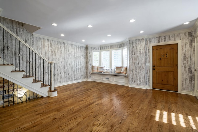 unfurnished living room with wood-type flooring and ornamental molding