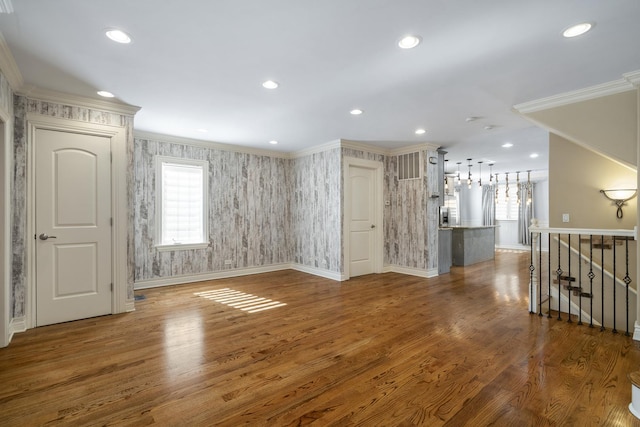 unfurnished living room with hardwood / wood-style floors and crown molding