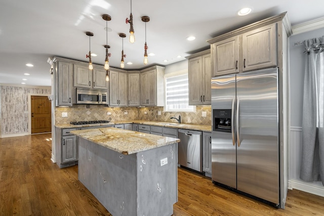 kitchen featuring a center island, dark hardwood / wood-style flooring, decorative light fixtures, light stone counters, and stainless steel appliances