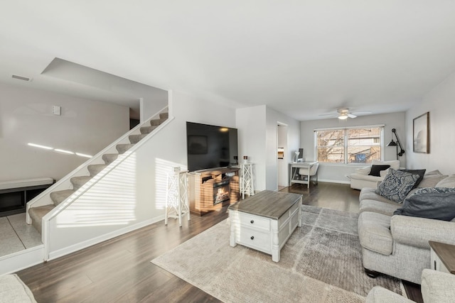 living room featuring ceiling fan and dark hardwood / wood-style floors