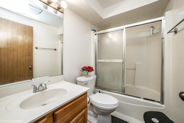 full bathroom featuring vanity, toilet, and bath / shower combo with glass door