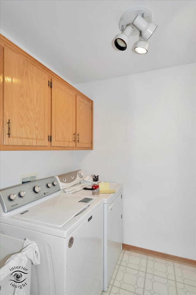 laundry area with cabinets and washer and clothes dryer