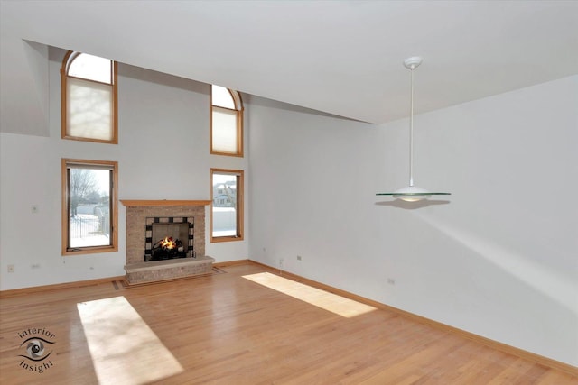 unfurnished living room with a high ceiling and light hardwood / wood-style floors