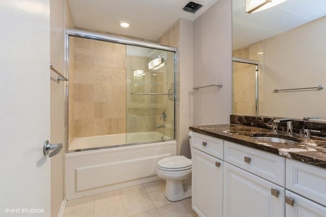 full bathroom featuring tile patterned flooring, vanity, toilet, and bath / shower combo with glass door