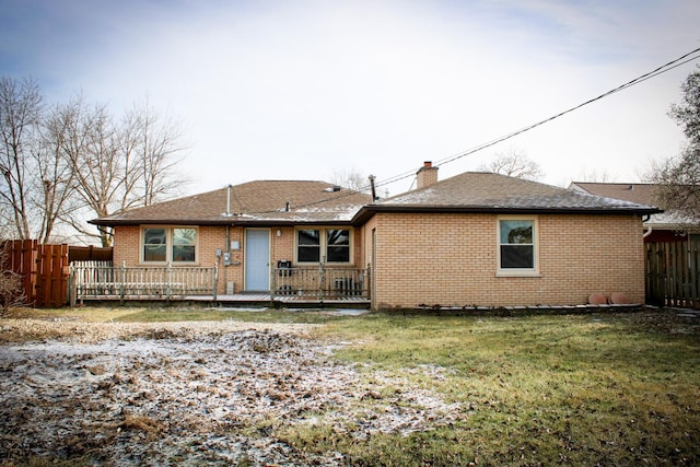 rear view of house featuring a wooden deck and a yard