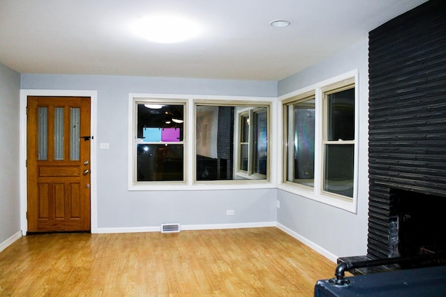 interior space featuring a large fireplace and light hardwood / wood-style floors