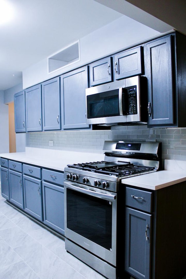 kitchen featuring gray cabinetry, backsplash, and appliances with stainless steel finishes