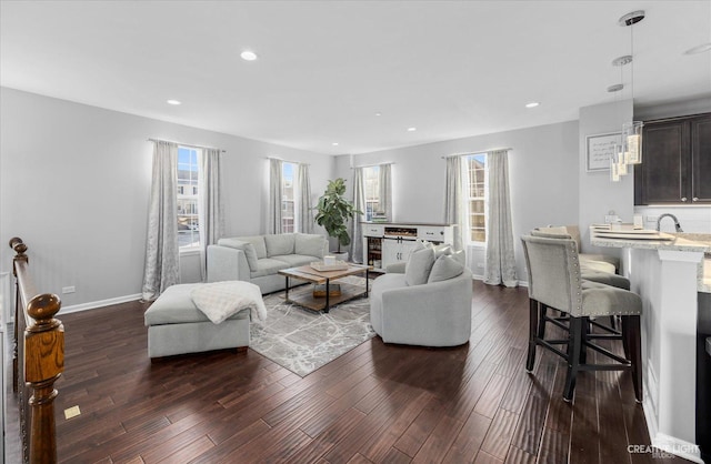 living room with dark hardwood / wood-style flooring and sink