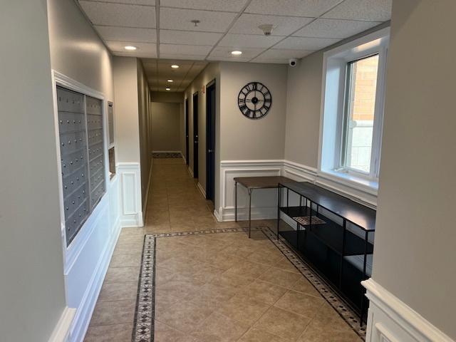 corridor featuring a mail area and light tile patterned floors