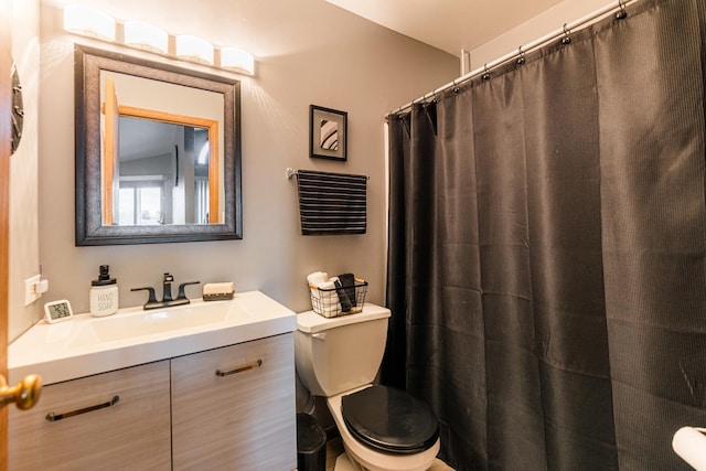 bathroom featuring vanity, curtained shower, and toilet