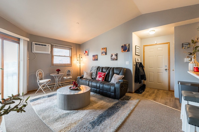 living room with hardwood / wood-style flooring, baseboard heating, a wall unit AC, and vaulted ceiling