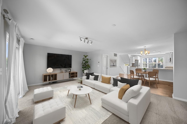 living room with a notable chandelier and light carpet