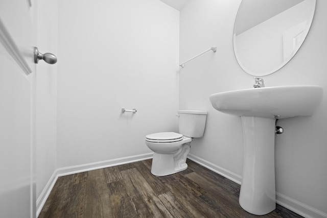 bathroom with hardwood / wood-style flooring and toilet