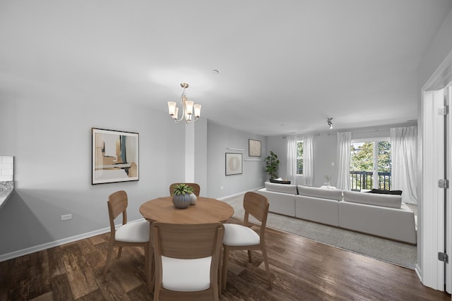 dining area featuring dark wood-type flooring and a chandelier