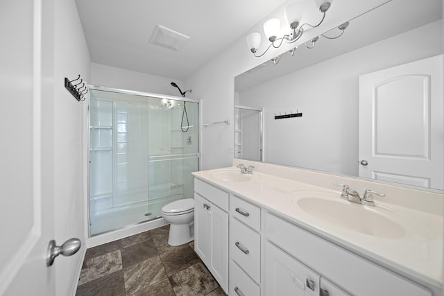 bathroom featuring vanity, toilet, and a shower with door