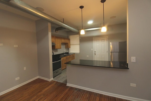 kitchen with pendant lighting, sink, dark wood-type flooring, stainless steel appliances, and kitchen peninsula