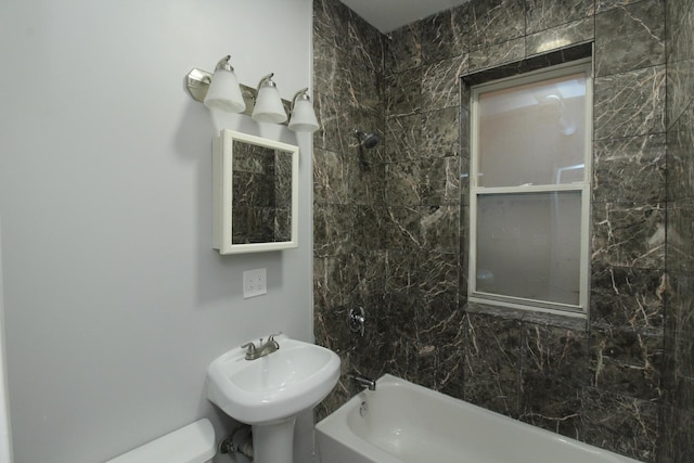 full bathroom with tiled shower / bath, toilet, and sink