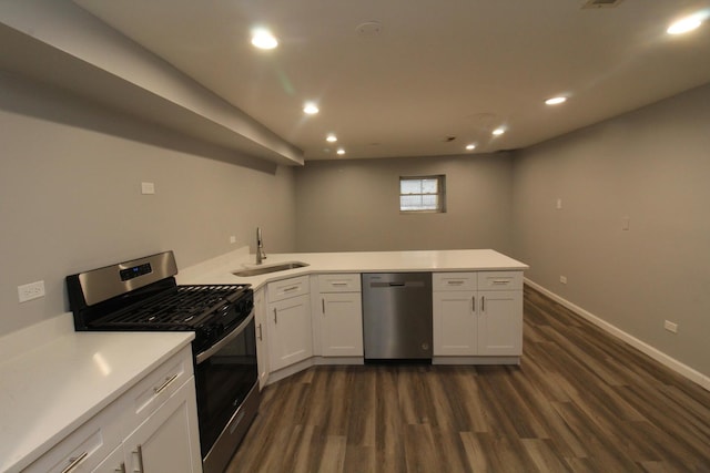 kitchen featuring sink, dark wood-type flooring, white cabinetry, stainless steel appliances, and kitchen peninsula