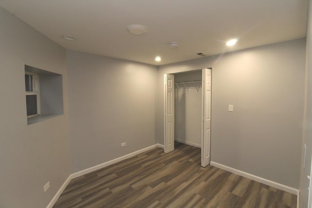 unfurnished bedroom with dark wood-type flooring and a closet