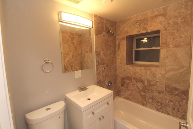 full bathroom featuring vanity, tiled shower / bath, and toilet