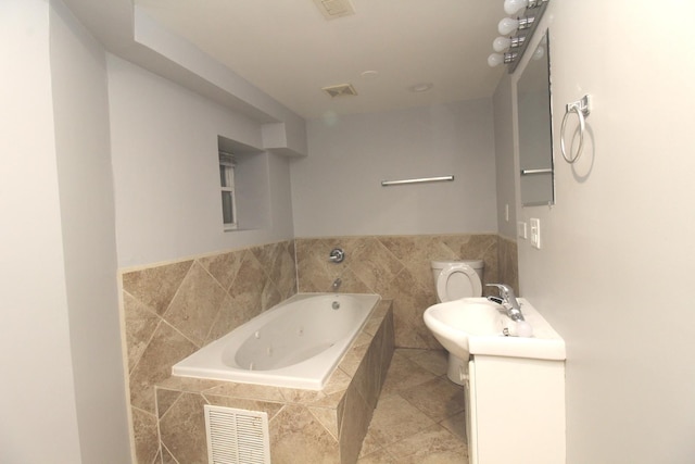 bathroom with vanity, a relaxing tiled tub, tile patterned floors, and toilet