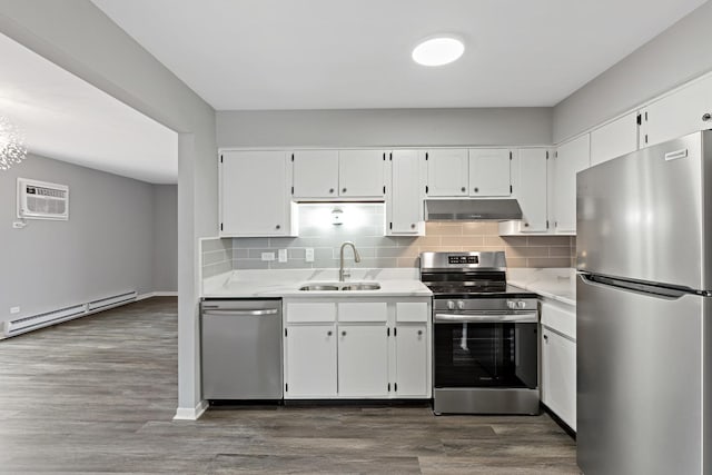 kitchen with white cabinets, sink, baseboard heating, dark hardwood / wood-style flooring, and stainless steel appliances