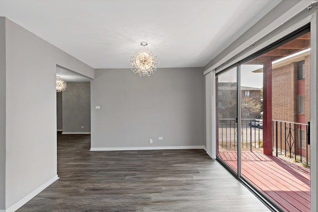 unfurnished room featuring dark hardwood / wood-style flooring and an inviting chandelier