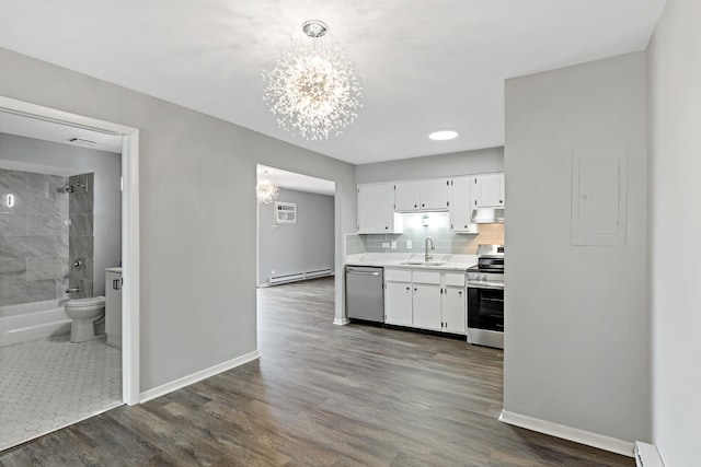 kitchen with white cabinets, decorative backsplash, appliances with stainless steel finishes, a baseboard radiator, and a chandelier