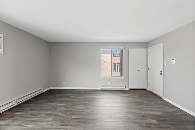 spare room featuring dark hardwood / wood-style floors and a baseboard heating unit