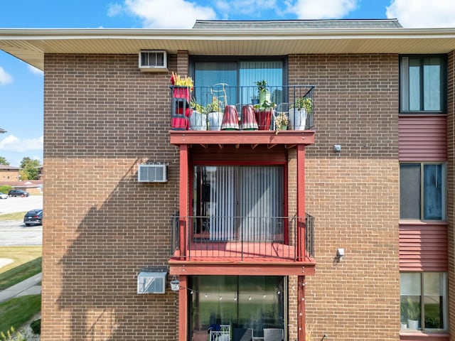 rear view of house featuring a wall unit AC