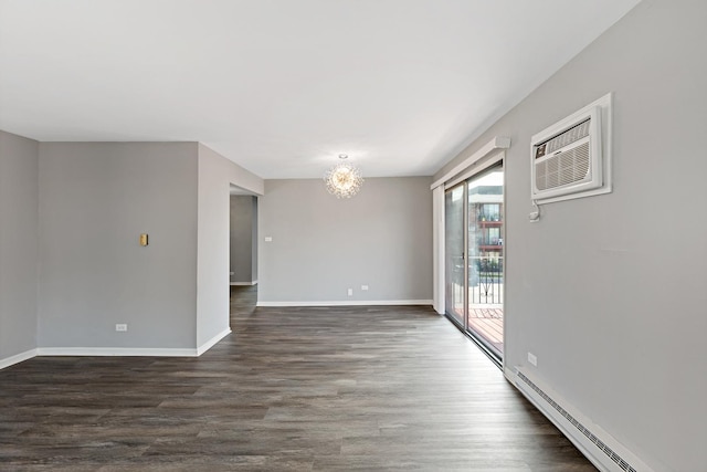 empty room featuring a chandelier, a wall mounted air conditioner, dark wood-type flooring, and a baseboard heating unit