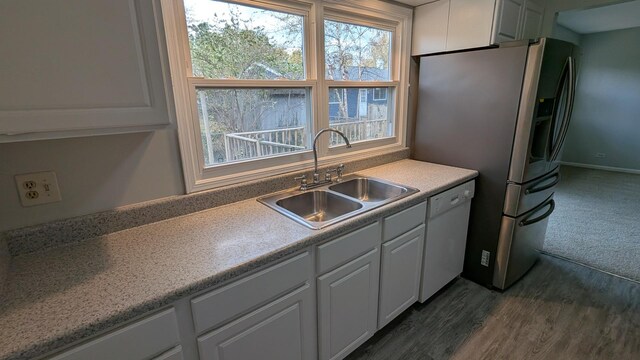 kitchen featuring stainless steel fridge with ice dispenser, white dishwasher, a sink, light countertops, and white cabinetry