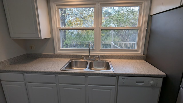 kitchen with a sink, dishwasher, a wealth of natural light, and white cabinetry