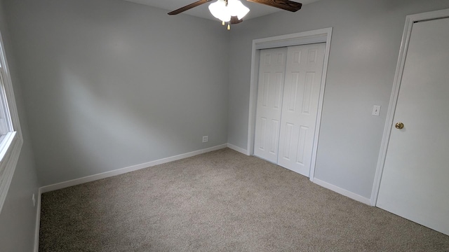 unfurnished bedroom with a closet, baseboards, carpet, and a ceiling fan