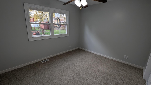 spare room featuring carpet, visible vents, and baseboards