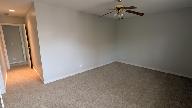 spare room with visible vents, light carpet, baseboards, and ceiling fan