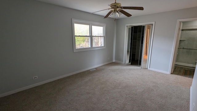 unfurnished bedroom with visible vents, baseboards, a closet, ensuite bathroom, and light carpet