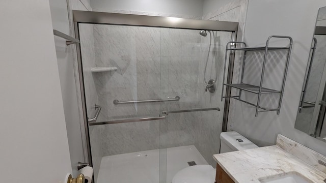 full bath with a stall shower, toilet, and vanity