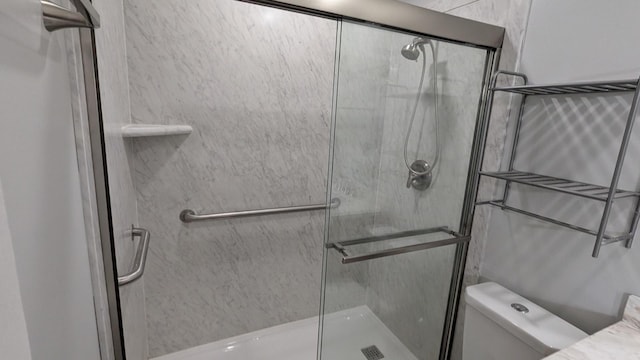 bathroom with a shower stall and toilet