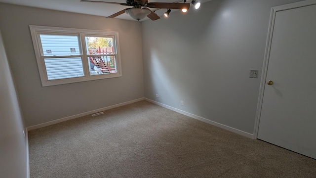 unfurnished room featuring carpet flooring, visible vents, a ceiling fan, and baseboards