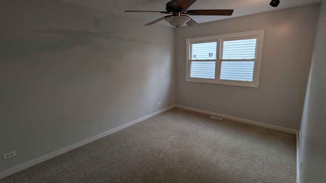 spare room with baseboards, carpet, and a ceiling fan