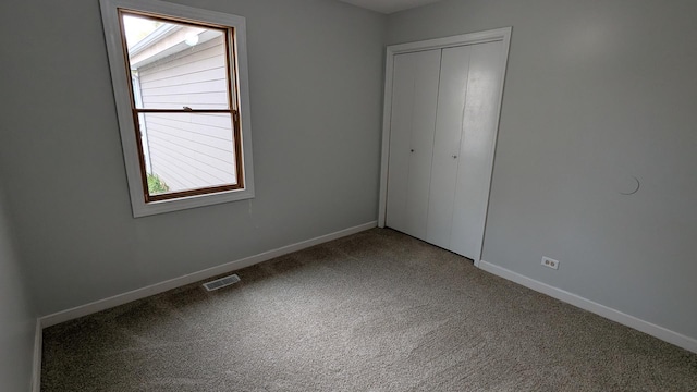 unfurnished bedroom featuring carpet, visible vents, a closet, and baseboards