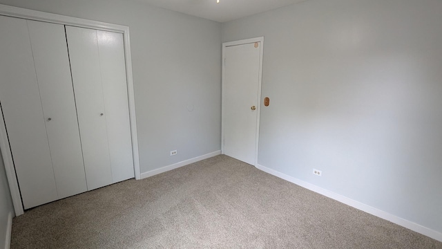 unfurnished bedroom featuring a closet, baseboards, and carpet floors