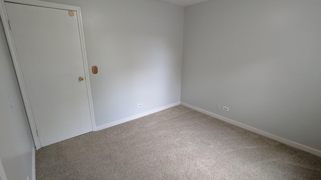 carpeted spare room with baseboards