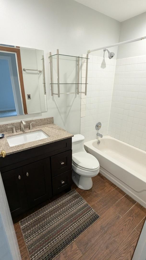 full bath with vanity, bathing tub / shower combination, toilet, and wood finished floors