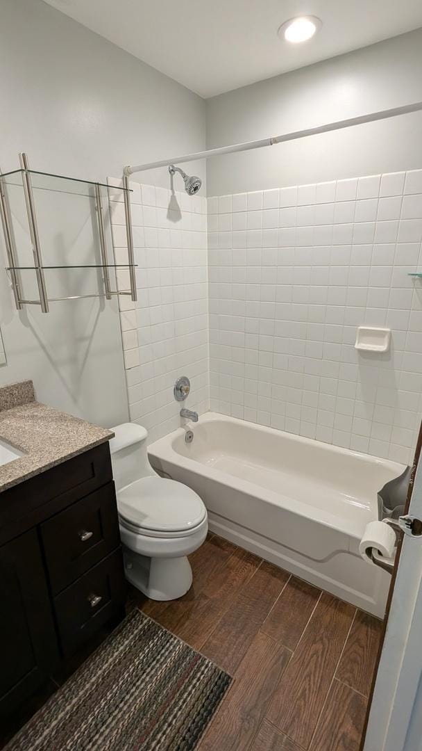 bathroom with vanity, shower / bathing tub combination, toilet, and wood tiled floor