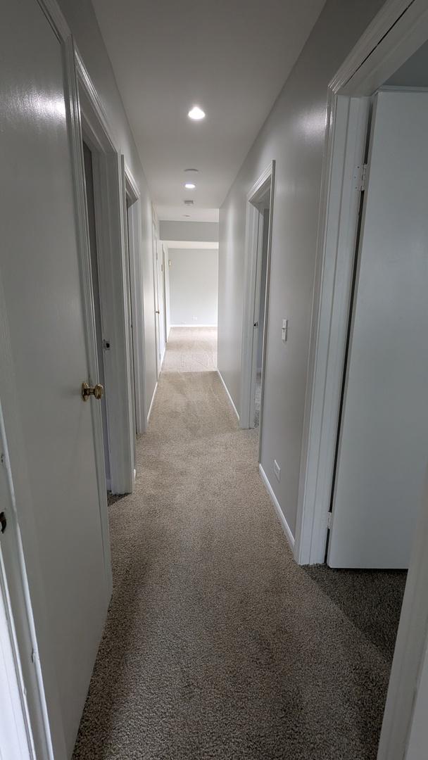 hall featuring recessed lighting, baseboards, and light colored carpet