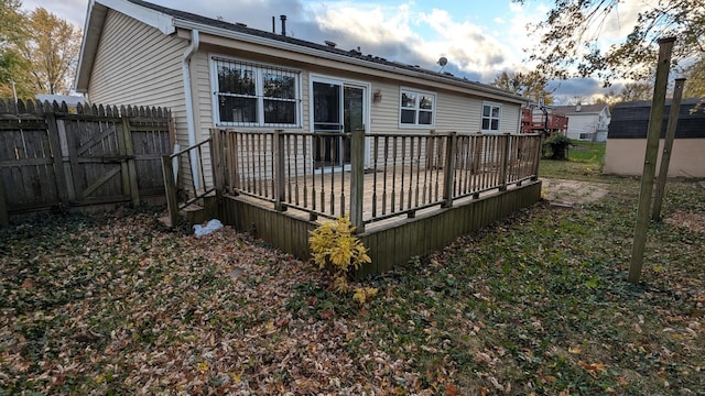 rear view of house with fence and a wooden deck