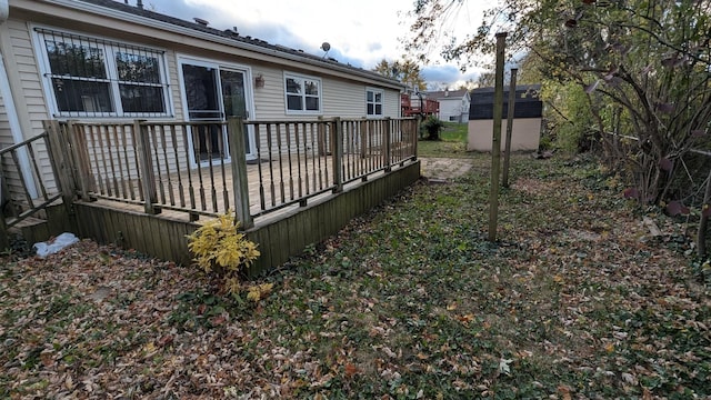 exterior space featuring an outbuilding, a deck, and a storage shed